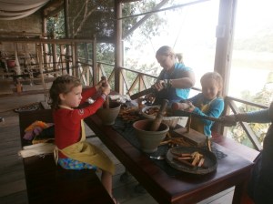 Maëlle écrase les graines d'annatto et Anaïk coupe le bois de sappan.